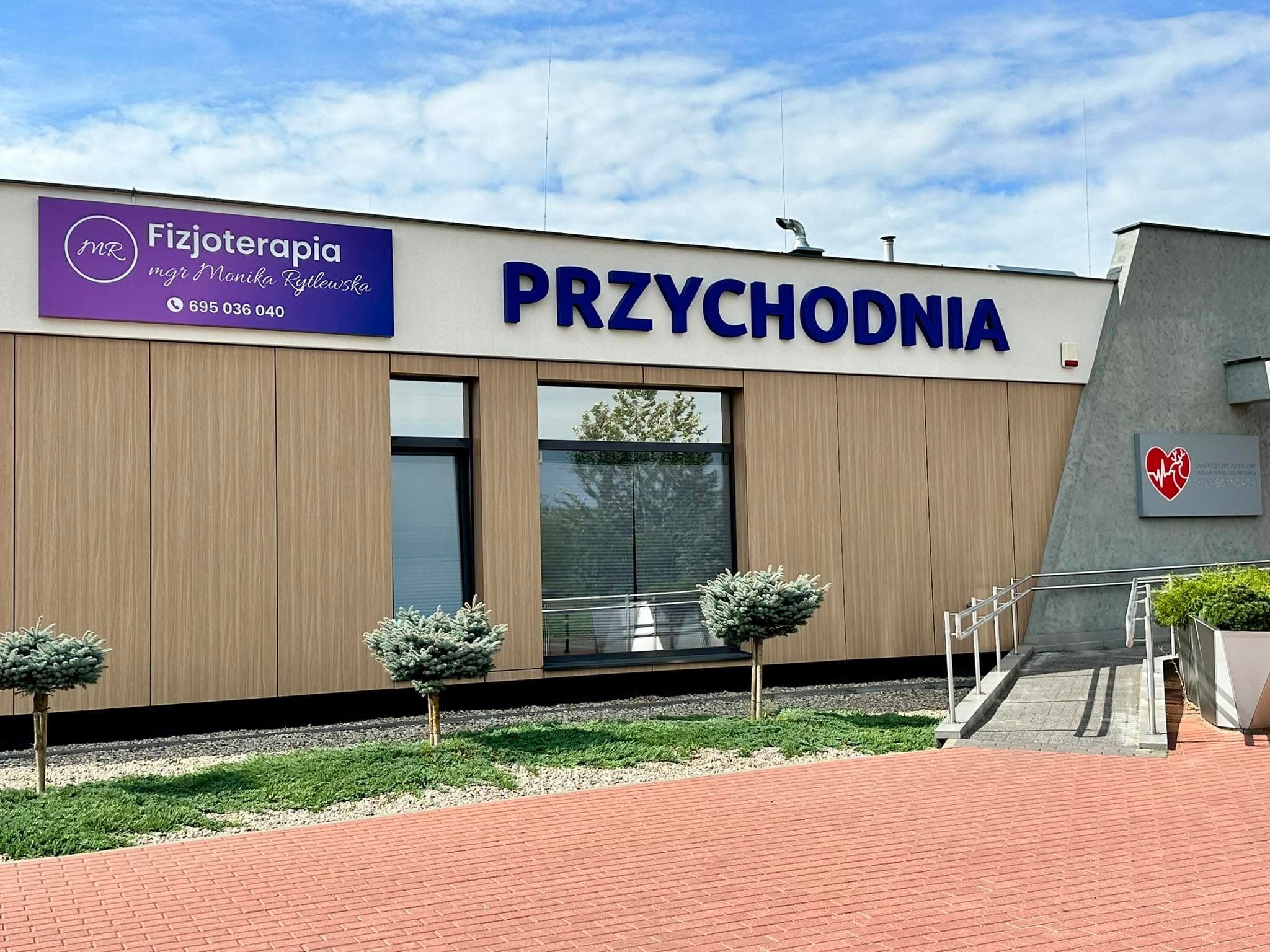Wejście do przychodni i szyld gabinetu Fizjoterapia mgr Monika Rytlewska